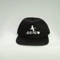 A black flat-brim cap with a white embroidered logo featuring a bird silhouette and the text 'AVENU' on the front, set against a light gray gradient background.